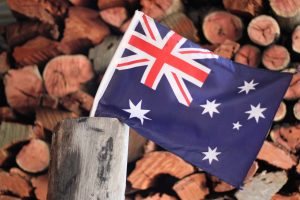 Australian flag in front of wood log stack